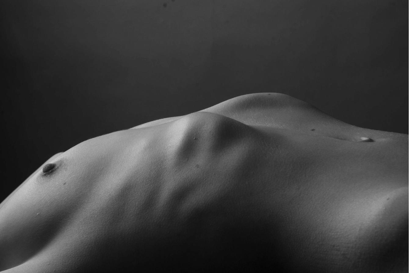 Chest and torso in black and white studio light - no face visible